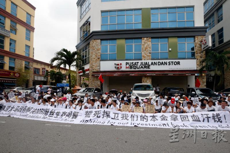 逾300名中国投资者在投资公司办公室楼下，拉开横幅静坐抗议，要求公司负责人出来面对。.jpg
